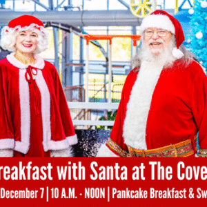 Santa Claus and Mrs. Claus stand smiling inside an indoor water park. Event details for “Breakfast with Santa at The Cove™” are displayed on a red banner at the bottom.