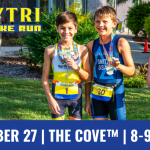 Three participants with medals stand together in athletic gear at a Playtri event. A banner reads "Playtri Swim Bike Run." The event details at the bottom state: "September 27 | The Cove™ | 8-9:30 A.M."