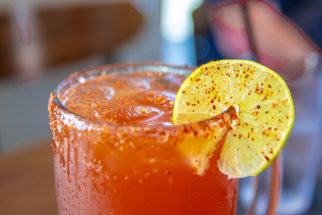 Tall glass of amber iced tea garnished with a lime slice, with a second glass partially visible beside it